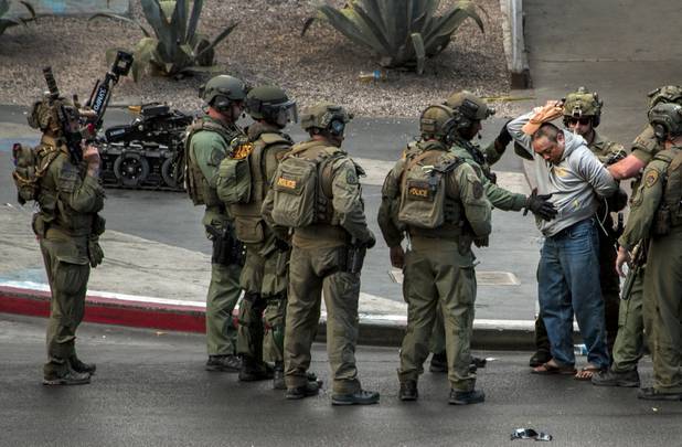 A suspect finally surrenders to SWAT officers after being barricaded for many hours on a bus after a fatal shooting in the vehicle earlier today along the Strip outside the Cosmopolitan Hotel on Saturday, March 25, 2017.