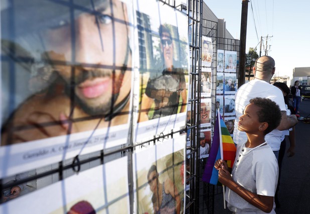 Zyane Oddo, 9, looks over a display featuring photos of the 49 Pulse nightclub shooting victims during a vigil at the Gay & Lesbian Community Center of Southern Nevada Monday, June 12, 2017. The vigil marked the one year anniversary of the shooting, the worst mass shooting in U. S. History.