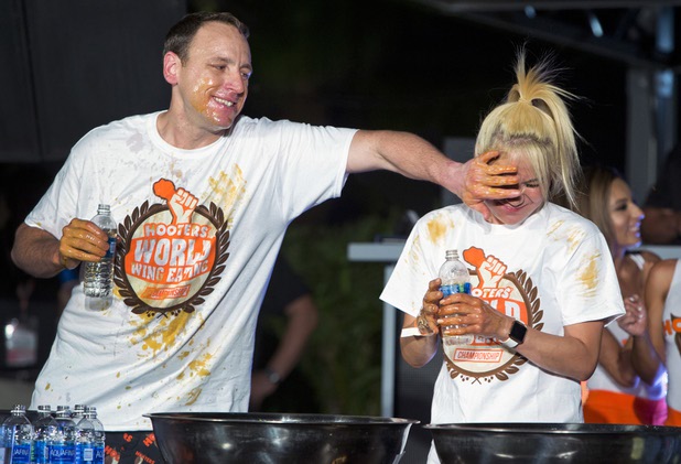 Defending champion Joey Chestnut wipes his hand on the face of Las Vegan Miki Sudo during the annual Hooters World Wing-Eating Championship at the Palms Monday, July 10, 2017.