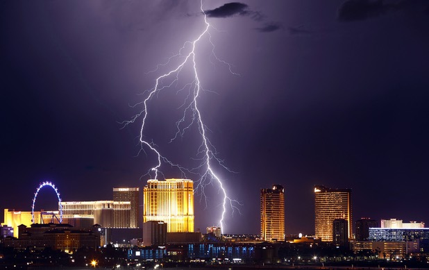 Lightning strikes behind Las Vegas Strip casinos as a thunderstorm passes through the northwest valley Wednesday, Sept. 13, 2017.