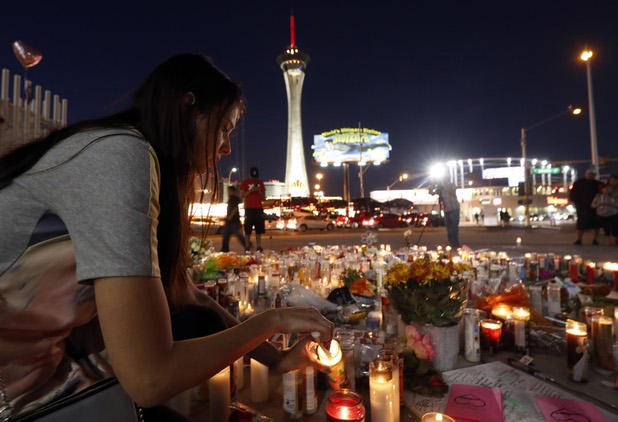 Dashenka Giraldo of Las Vegas lights candles at a makeshift memorial for shooting victims at the Las Vegas Strip and Sahara Avenue Wednesday, Oct. 4, 2017.