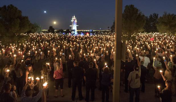 Thousands gather with lit candles for a ceremony for fallen Officer Charleston Hartfield at the Police Memorial Park on Thursday, October 5, 2017.   .