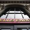 This Friday, Aug. 11, 2017, file photo shows a sign at a Wells Fargo bank location in Philadelphia. Wells Fargo stands to benefit from the new tax overhaul.
