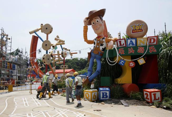 In this Sept. 8, 2011, file photo, workers walk past "Toy Story" character Woody at the construction site of the new attraction area Toy Story Land in Hong Kong Disneyland. A new 11-acre Toy Story Land is planned for Walt Disney World Resort near Orlando, Fla., in 2018, opening at the theme park's Hollywood Studios.