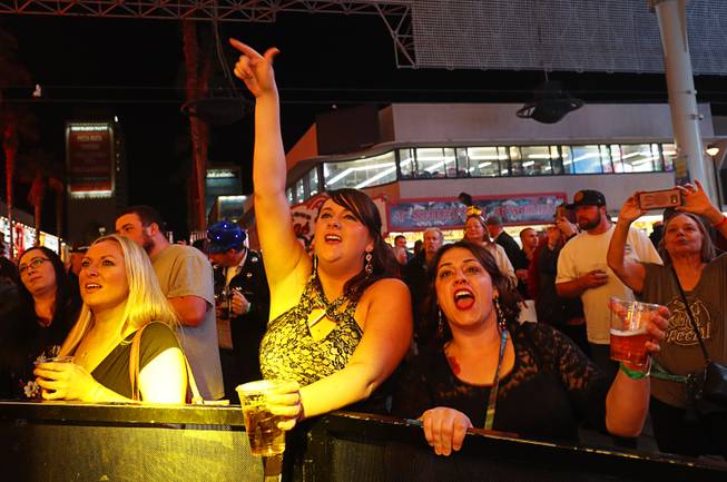 Heather Cox, left, Kennedy Myler, center, and Mallory Braby of Pisgah, Iowa sing along to live music during the New Year's Eve Party at the Fremont Street Experience in downtown Las Vegas, Sunday, Dec. 31, 2017.