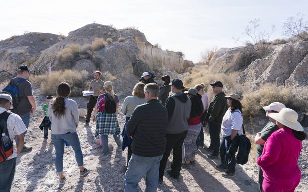 Visitors listen to Park Ranger Garrett Fehner as he talks about an almost mile-long trench (seen in the background) that remains from a 1960's famous paleontology expedition called the "Big Dig" at Ice Age Fossils State ParkLas Vegas' newest state park where visitors can explore and learn about fossil beds located in the areaduring a ranger-guided hike, Monday, Jan. 1, 2018. With the park still in development, a visitor's center, interpretive trails and more infographic signs are expected to complete the park within two years.