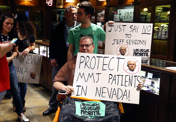 Peter Loughead, in wheelchair, displays a sign during a news conference at the Apothecary Shoppe marijuana dispensary on West Flamingo Road Thursday, Jan. 04, 2018. Loughead, who suffers from multiple sclerosis (MS), said he relocated to Nevada from Missouri in order to get treated with medical marijuana.