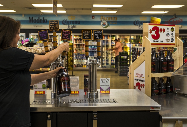 Speedee Mart gas station manager Vickie Snyder pours a growler ...