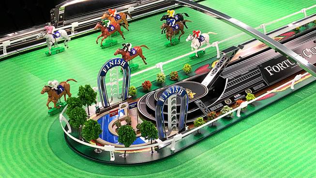 The basic action of the Fortune Cup game is a series of tiny horse figurines “racing” around a track roughly the size of a foosball table.