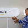 In this Monday, Oct. 16, 2017, photo, Migdawlaw Yisrael, a staffer at the University of Alabama at Birmingham's Hill Student Center, pushes a large Amazon Dash button, in Birmingham, Ala. The large Dash buttons are part of the city's campaign to lure Amazon's second headquarters to Birmingham.