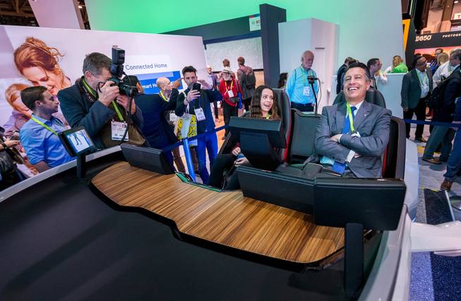 Gov. Brian Sandoval, right, "relaxes" behind the wheel of an autonomous car demonstration as his daughter Marisa Sandoval looks on from the passenger seat during a tour of the Bosch booth at CES in the Las Vegas Convention Center on Thursday, Jan. 11, 2018. 