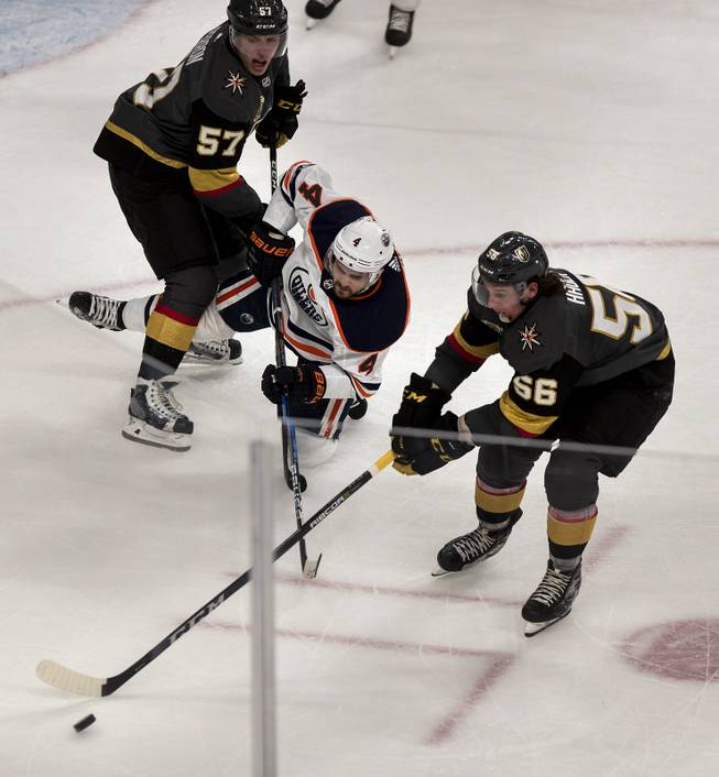 Vegas Golden Knights left wing David Perron (57) checks Edmonton Oilers defenseman Kris Russell (4) as Vegas Golden Knights left wing Erik Haula (56) controls the puck during their game at the T-Mobile Arena on Saturday, Jan. 13, 2018.  L.E. Baskow