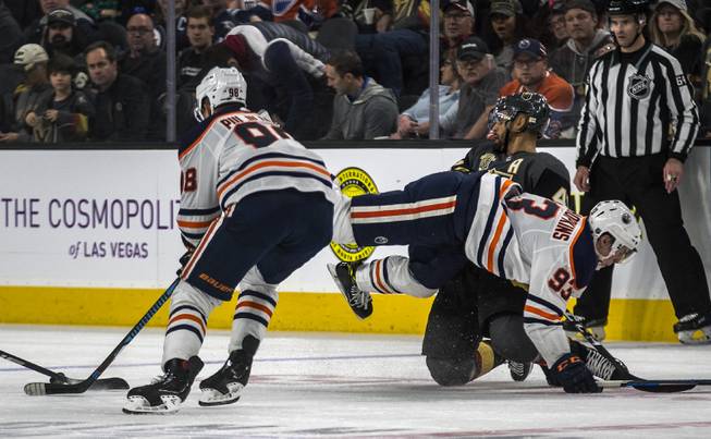 Edmonton Oilers right wing Jesse Puljujarvi (98) battles for the puck as Edmonton Oilers center Ryan Nugent-Hopkins (93) is knocked into Vegas Golden Knights left wing Pierre-Edouard Bellemare (41) during their game at the T-Mobile Arena on Saturday, Jan. 13, 2018.  L.E. Baskow
