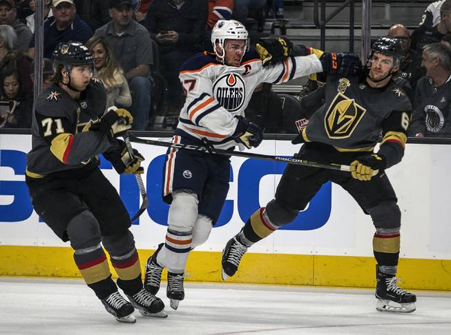 Vegas Golden Knights center William Karlsson (71) moves in as Edmonton Oilers center Connor McDavid (97) and Vegas Golden Knights defenseman Colin Miller (6) trade blows during their game at the T-Mobile Arena on Saturday, Jan. 13, 2018.  L.E. Baskow