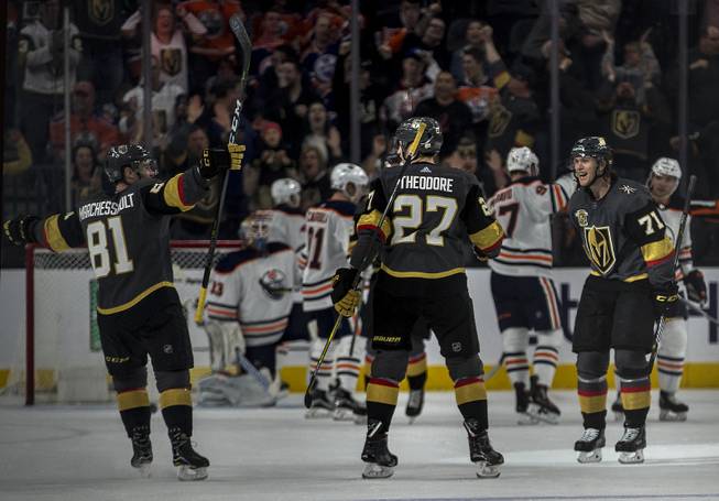 Vegas Golden Knights center William Karlsson (71) celebrates his score over the Edmonton Oilers with teammates Vegas Golden Knights defenseman Shea Theodore (27) and Vegas Golden Knights center Jonathan Marchessault (81) during their game at the T-Mobile Arena on Saturday, Jan. 13, 2018.  L.E. Baskow