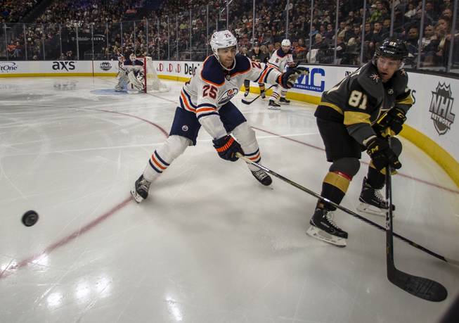 Vegas Golden Knights center Jonathan Marchessault (81) and Edmonton Oilers defenseman Darnell Nurse (25) eye a puck during their game at the T-Mobile Arena on Saturday, Jan. 13, 2018.  L.E. Baskow