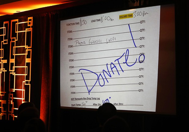 "Donate!" is shown as a video is played during a news conference at the Three Square food bank Wednesday, Jan. 17, 2018. MGM Resorts International announced a surplus banquet food donation program they hope will provide 800,0000 meals by 2020.