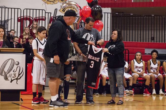 Joe, second to right, and Tracey Robbins, right, parents of Quinton Robbins, an Oct. 1 shooting victim, accept a #3 Bears jersey during an emotional Clark County School District tribute ceremony at B. Mahlon Brown Academy of International Studies for Quinton Robbins, Wednesday, Jan. 17, 2018.  An active participant of school sports, Robbins' #3 jersey was retired during the ceremony.