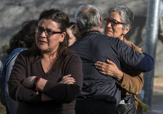 Individuals console each other as Sheyla Padilla, daughter of Celia Luna, addresses the media during a plea for information related to her mother's recent homicide at the Express Cash Checking on Jones Boulevard near Vegas Drive on Thursday, Jan. 18, 2018.