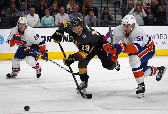 Golden Knights left wing Brendan Leipsic (13) chases after a puck with New York Islanders defenseman Sebastian Aho (28) and defenseman Adam Pelech (50) during the third period at T-Mobile Arena Thursday, Jan. 25, 2018.