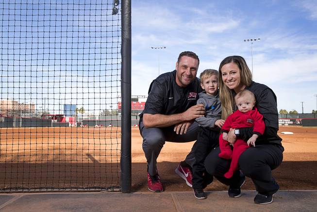 UNLV head softball coach Kristie Fox-Jarvis poses with her son Mikie, 4 months, her husband and assistant coach Andy Jarvis and "Little Andy," 2, in a dugout at the Eller Media Softball Stadium at UNLV Saturday, Jan. 27, 2018.