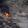 In this Saturday, Feb. 10, 2018, photo, a survivor, lower right, walks away from the scene of a deadly tour helicopter crash along the jagged rocks of the Grand Canyon, in Arizona.
