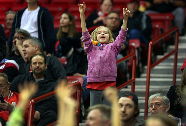 A Rebels fan, hoping for a free T-shirt, jumps during ...