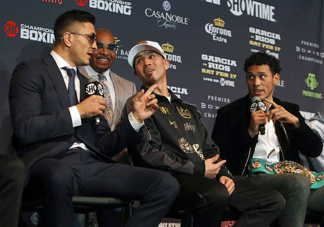 Welterweight boxer Brandon Rios, center, gets caught in the middle of an exchange of words between Ronald Gavril, left, of Las Vegas and WBC super middleweight champion David Benavidez of Phoenix during a news conference at the Mandalay Bay Thursday, Feb. 15, 2018.