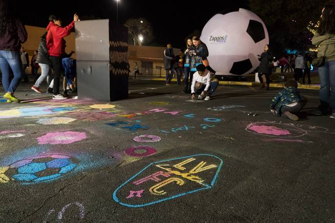 Kids draw on the asphalt during the tailgaite party prior to the Lights spring training match against the Vancouver Whitecaps Saturday, February 17, 2018 at Cashman Field.