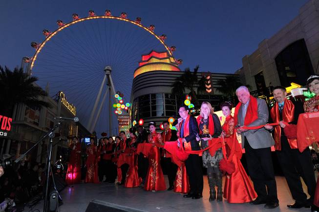 Xiao Xiayong, sixth right, Consulate General of the People's Republic of China culture counselor; Eileen Moore, fifth right, regional president for Caesars Entertainment and Clark County Commissioner Steve Sisolak, third right, cut a ceremonial ribbon beginning the Chinese New Year celebration at The Linq Promenade Friday, Feb. 16, 2018, in Las Vegas.