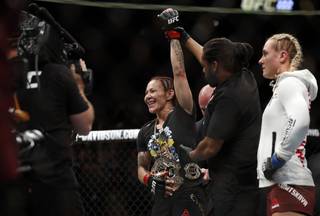 Women's featherweight champion Cris Cyborg of Brazil celebrates her first round TKO victory over Yana Kunitskaya, right, of Russia during UFC 222 at T-Mobile Arena Saturday, March 3, 2018. 