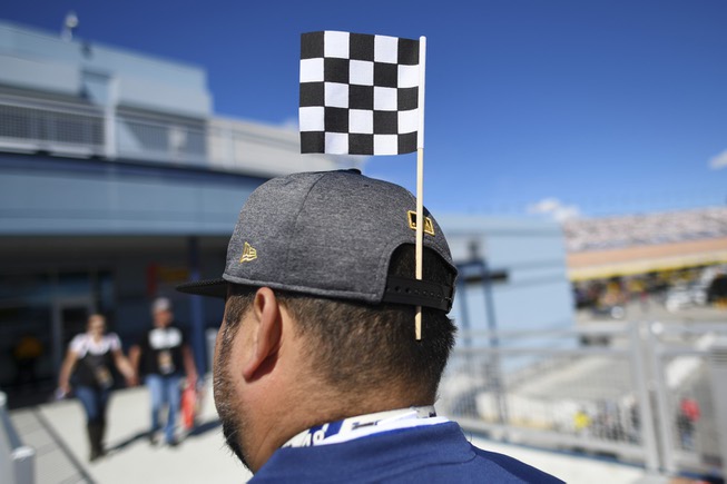 A man wears a checkered flag in his hat during ...