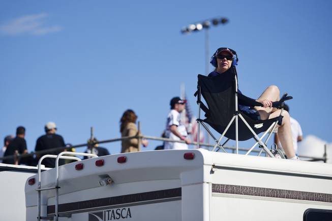 A woman watches the race from the top of an RV during the Monster Energy NASCAR Cup Series Pennzoil 400 Sunday, March 4, 2018, at the Las Vegas Motor Speedway.