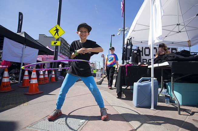 Ryan Milan, 10, of Oxnard, Calif., shows off his hula skills by a Hooker Racing tent during a Mint 400 tech and contingency event on East Fremont Street in downtown Las Vegas Friday, March 9, 2018. The Mint 400 off road race takes place Saturday in Primm.