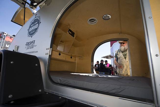 Dave Desmarais of Henderson looks over a self-contained Rebel teardrop trailer by Off The Grid Rentals during a Mint 400 tech and contingency event on East Fremont Street in downtown Las Vegas Friday, March 9, 2018. The Mint 400 off road race takes place Saturday in Primm.