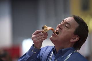 Scott Leach bites into a slice of pizza during the annual International Pizza Expo Tuesday, March 20, 2018, at the Las Vegas Convention Center.