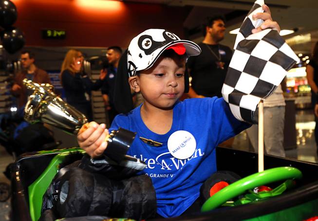 Make-A-Wish recipient Nicolas "Quatro" Dones IV adjusts a checkered flag on his mini-mister truck at McCarran International Airport Wednesday, March 21, 2017. Quatro arrived on Allegiant Air's 1,000th wish flight. A monster truck fan, Quatro wanted to come to Las Vegas to attend this weekend's Monster Jam World Finals XIX at Sam Boyd Stadium.