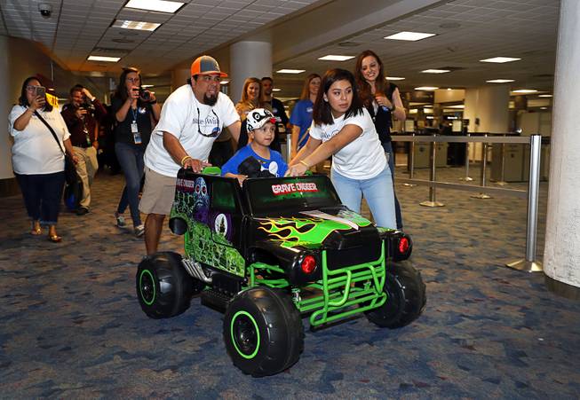 Make-A-Wish recipient Nicolas "Quatro" Dones IV makes his way to baggage claim, with help from his father Nicolas Dones III his sister Iliana, 16, at McCarran International Airport Wednesday, March 21, 2017. Quatro arrived on Allegiant Air's 1,000th wish flight. A monster truck fan, Quatro wanted to come to Las Vegas to attend this weekend's Monster Jam World Finals XIX at Sam Boyd Stadium.