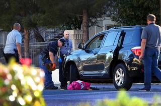 Metro Police investigators look over a car after a fatal accident involving a 9-year-old boy near Silvestri Middle School Friday, March 23, 2018.