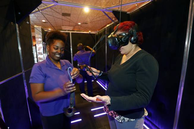 VR guide Brittany La'Rae Mabon helps set up Candy Haydel for an archery game at the Virtual Reality Zone at the Orleans Friday, March 23, 2018. STEVE MARCUS