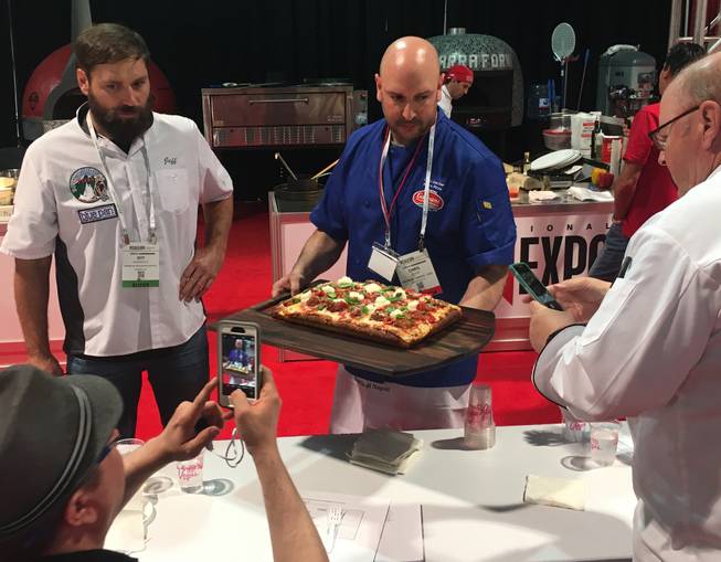 Metro Pizza's Chris Decker presents his Sicilian-style pizza to the judges of the International Pizza Challenge at the 34th annual International Pizza Expo on March 21 at the Las Vegas Convention Center.
