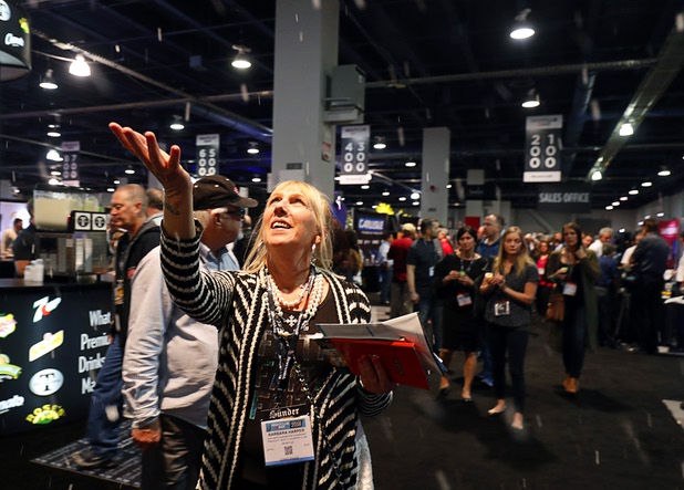 Barbara Harper catches dry "snow" as she passes by the CITC Special Effects booth during the annual Nightclub and Bar Show at the Las Vegas Convention Center Tuesday, March 27, 2018.