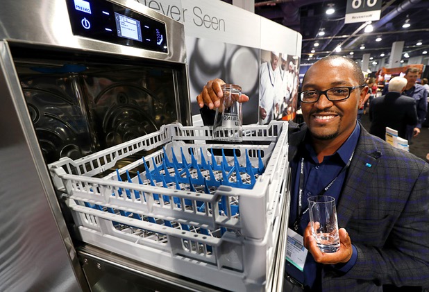 Cedric Stinson poses by the M-iCLEAN US mini-dishwasher during the annual Nightclub and Bar Show at the Las Vegas Convention Center Tuesday, March 27, 2018. The undercounter dishwasher is perfect for bars and taverns with limited space, Stinson said.