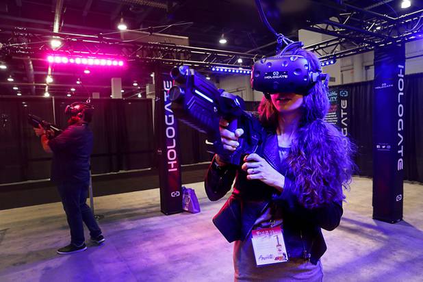 Juliette Reyes joins in a multi-player, virtual reality shooting game at the Hologate booth during the annual Nightclub and Bar Show at the Las Vegas Convention Center Tuesday, March 27, 2018.