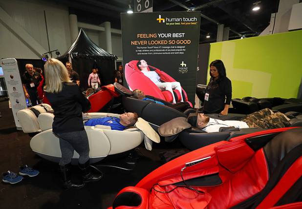 Attendees try out Human Touch Novo XT massage chairs during the annual Nightclub and Bar Show at the Las Vegas Convention Center Tuesday, March 27, 2018.
