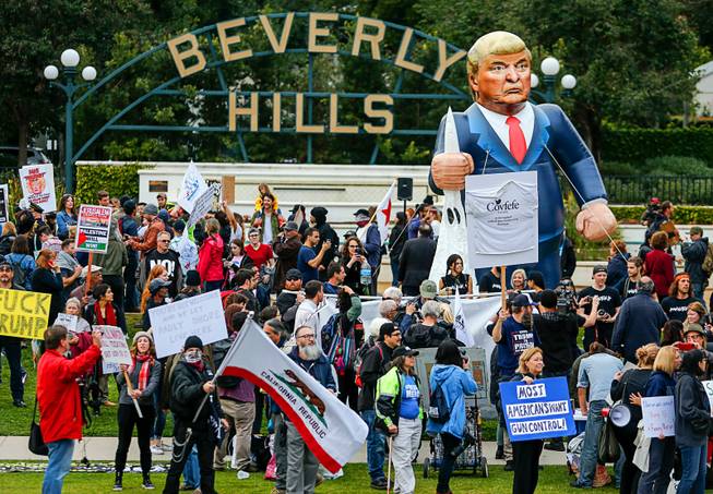 In this March 13, 2018 file photo, a pop-up inflatable President Donald Trump is erected during a rally against a scheduled visit by President Trump in Beverly Hills, Calif. The Trump administration is suing California over a law that aims to give the state power to override the sale of federal lands. The U.S. Department of Justice filed the lawsuit Monday, April 2, 2018. 