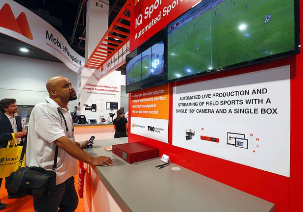 Corey Clarke, Pennsylvania Cable Network's Philadelphia bureau chief, looks over a Mobile Viewpoint automated sports production system during the National Association of Broadcasters (NAB) show at the Las Vegas Convention Center Tuesday, April 10, 2018. The system uses artificial intelligence software to follow the action.