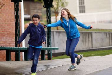 In this April 6, 2018, photo, Caleb Coulter, 10, left, and his sister Kendra, 12, play tag during a visit to the Place Heritage Park in Salt Lake City. Critics say letting children strike out on their own can expose them to serious dangers.