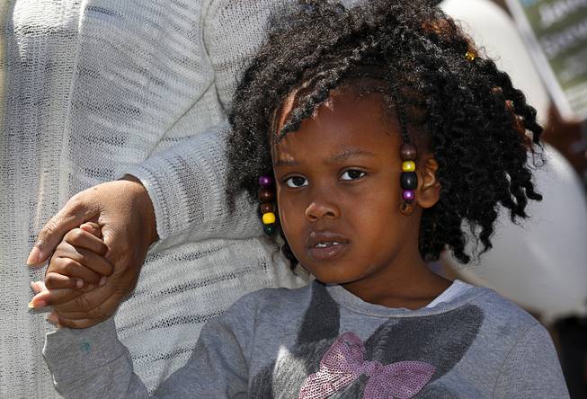 Aubrielle Stevenson, 5, holds her grandmother's hand during a remembrance rally for her father Javerian Stevenson at Liberty Baptist Church Thursday, April 12, 2018. Javerian Stevenson, 22, was killed when someone shot into a car window on Dune Drive on April 29, 2014.