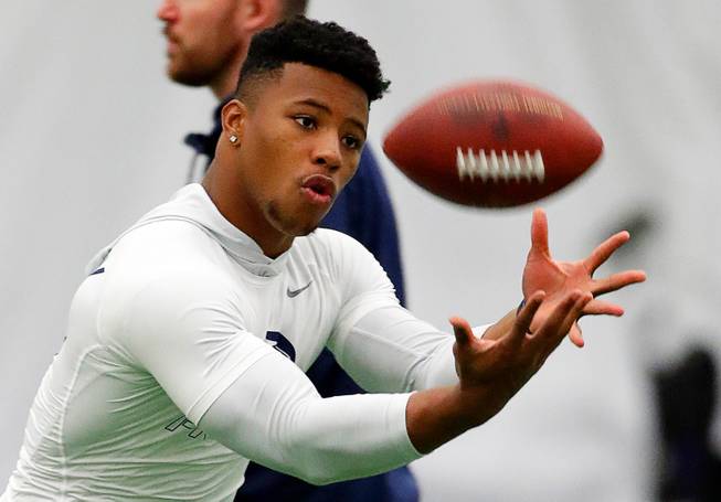 This March 20, 2018, file photo shows running back Saquon Barkley catching a football during Penn State NFL football Pro Day in State College, Pa. Barkley is the best player in this year's draft. Yet he might not go in the first handful of picks Thursday night. Huh? Blame the desperation to find quarterbacks in great part for the possibility that the Penn State All-America running back could fall well below where his talent, character and versatility warrant. 